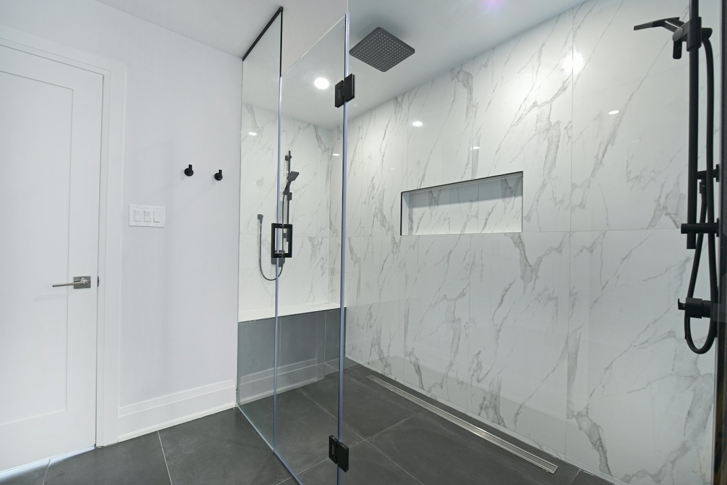 Modernes Badezimmer mit begehbarer Dusche aus Marmorfliesen.