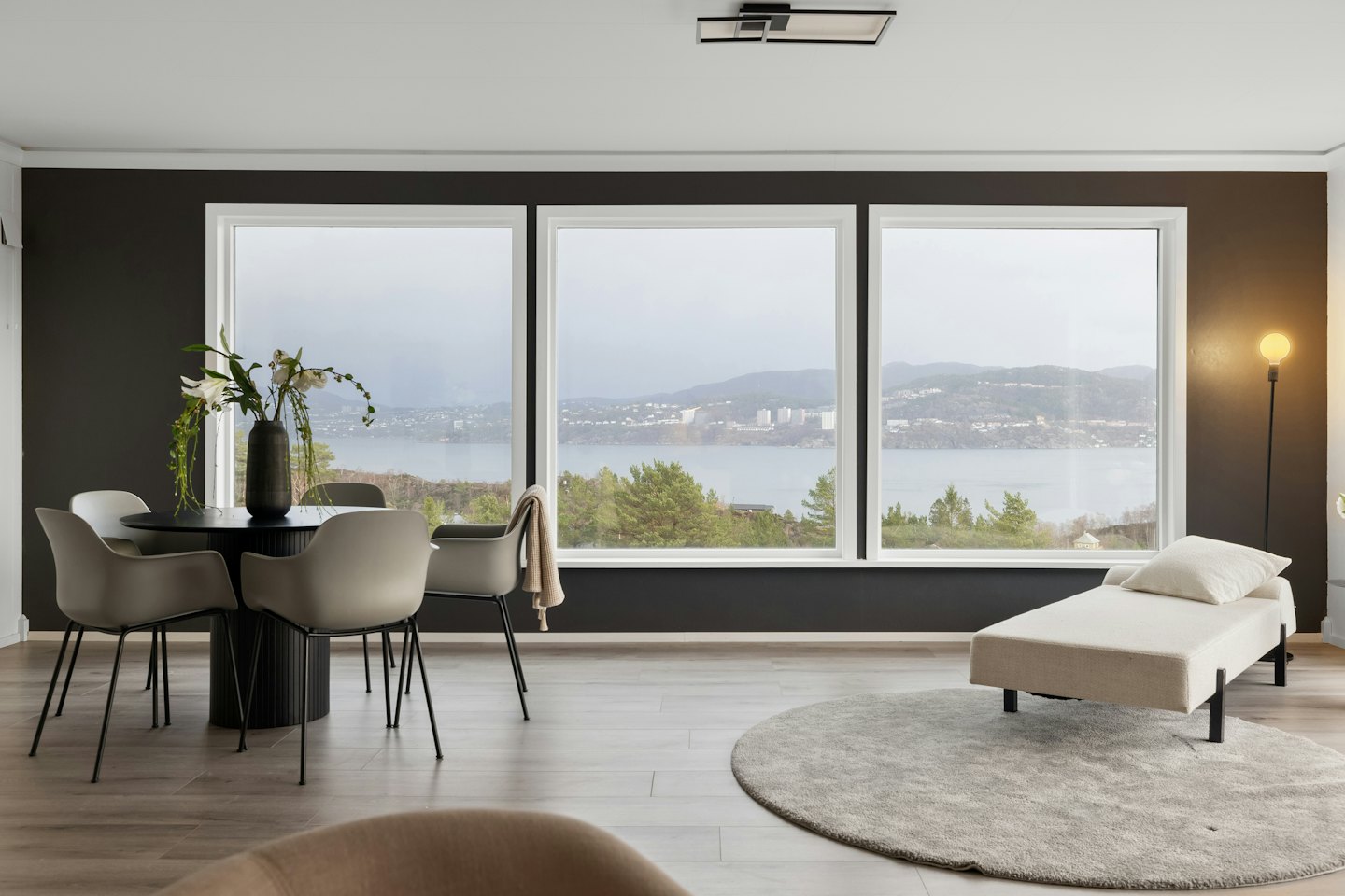 Modernes Wohnzimmer mit Blick auf eine Bucht mit Hügeln.