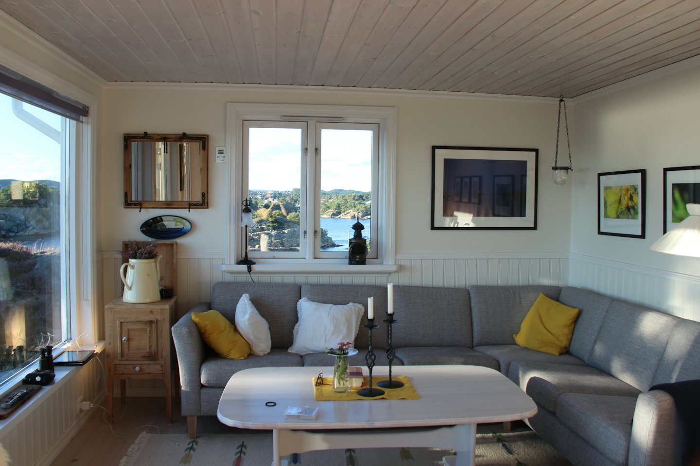 Wohnzimmer mit L-förmigem Sofa und Meerblick.
