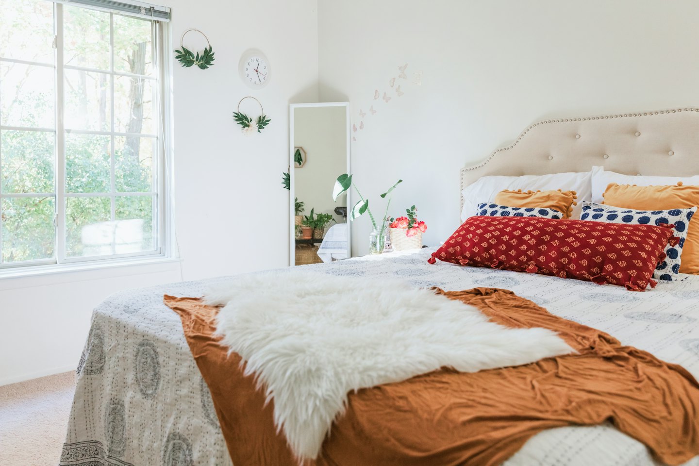 Schlafzimmer mit einem ordentlich gemachten Bett und Tageslicht.